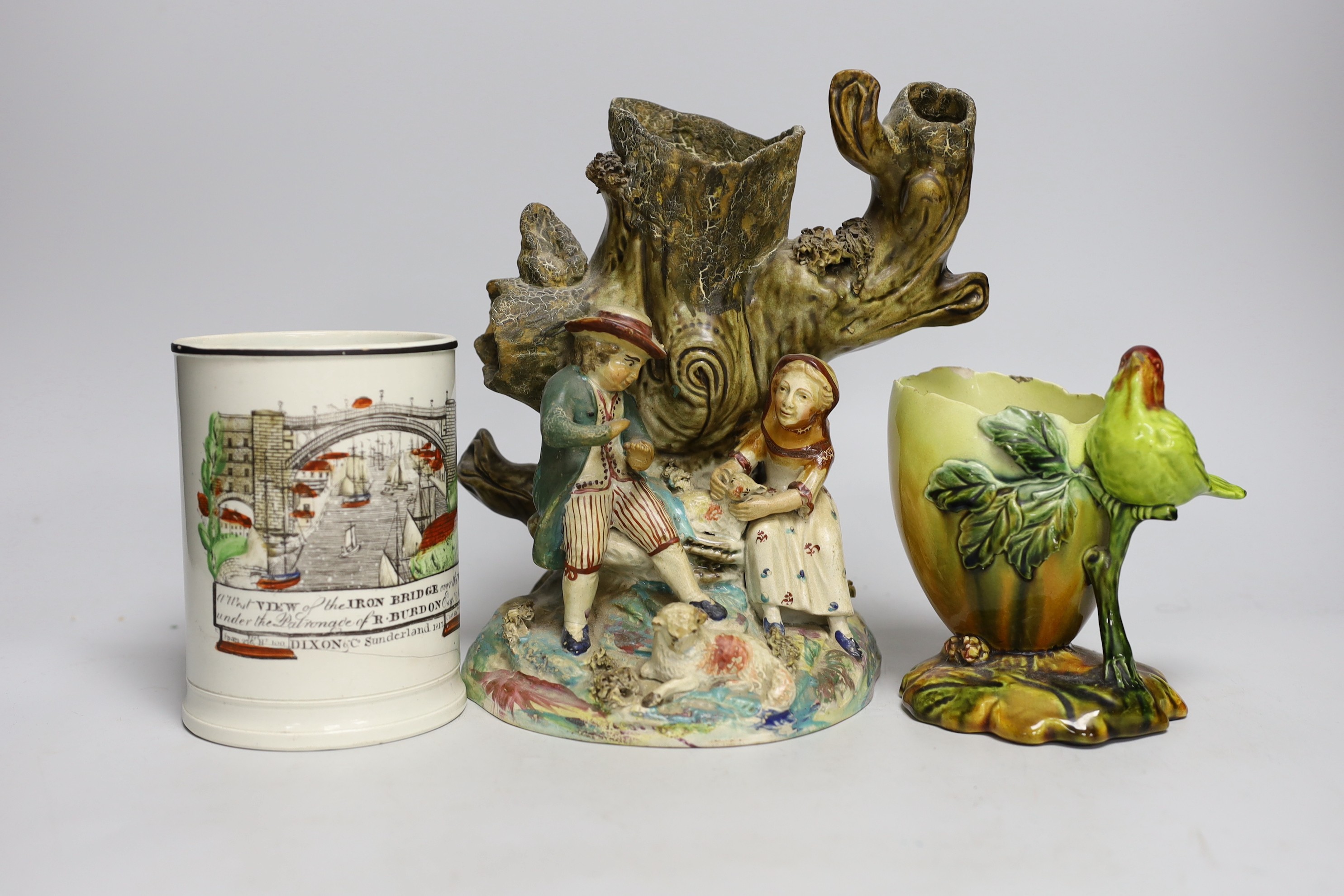 An early Staffordshire figure group, a Bretby egg shaped vase and a 19th century Iron Bridge frog tankard, figure group 24cms high